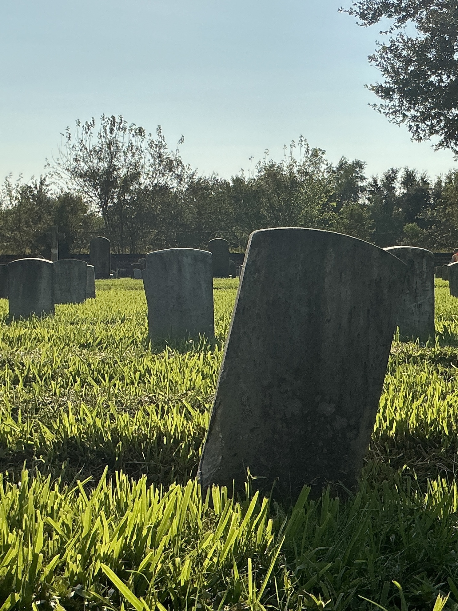 Back of historic upright marble headstone with recessed shield face.