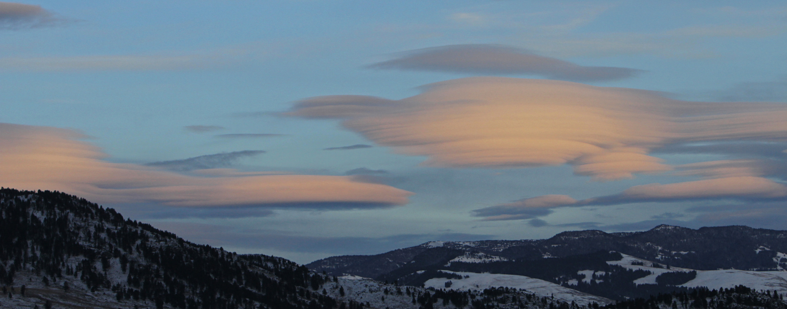Layered clouds over rolling hills.