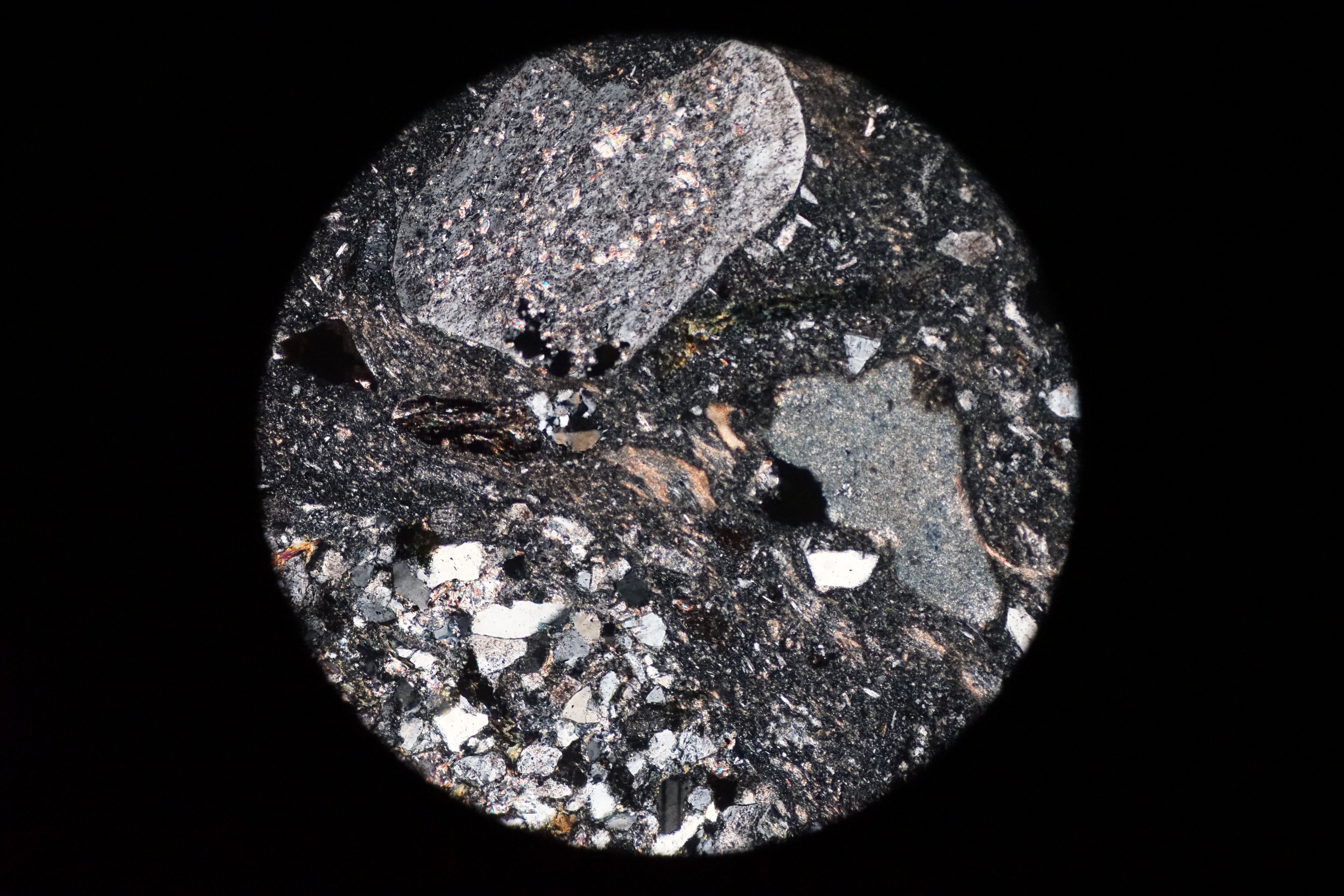 Circular microscopic image of rock structure.