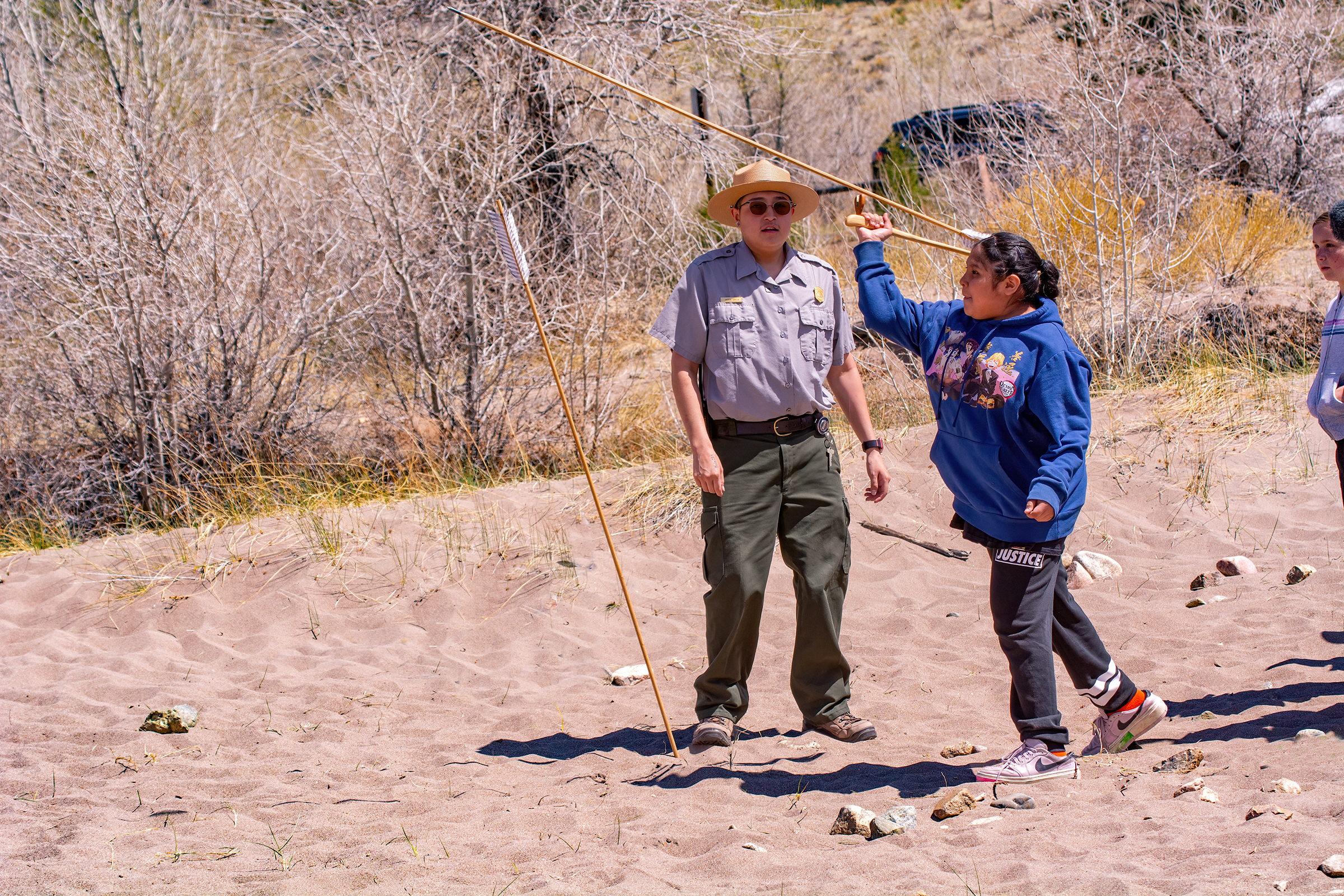 A student from the Jicarilla Apache Nation launches a long dart with an atlatl during a presentation by Jicarilla Apache Park Ranger Jaiden Garcia.
