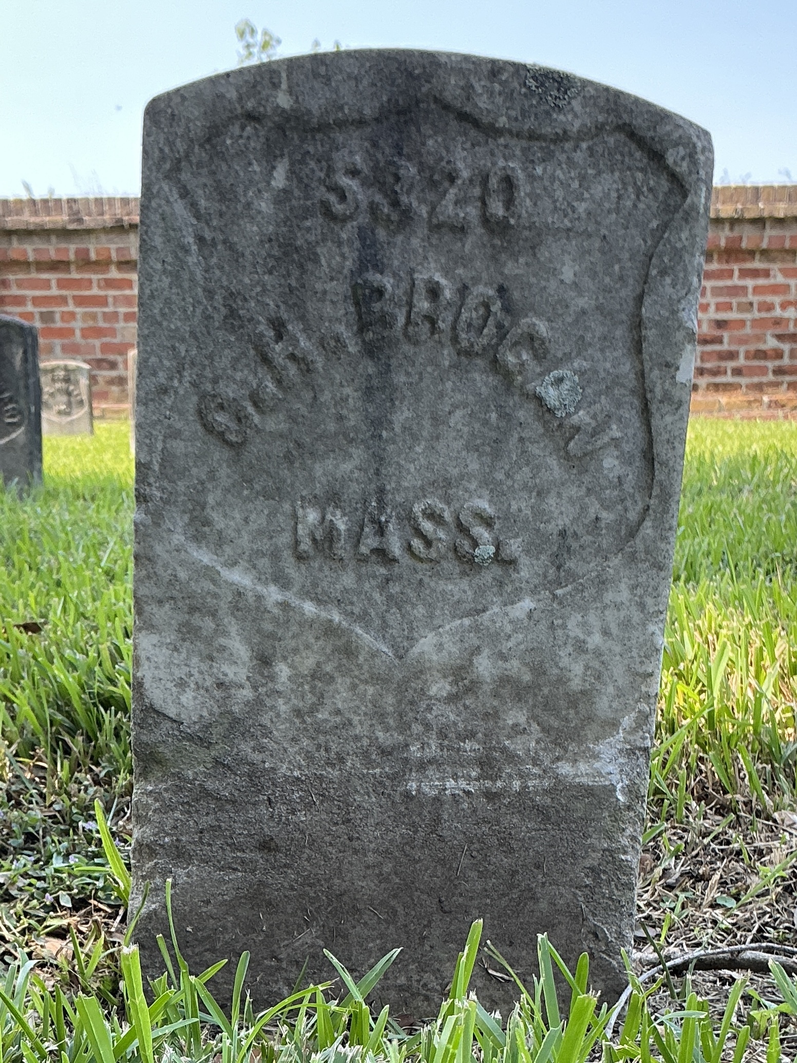 Front of historic upright marble headstone with recessed shield face.