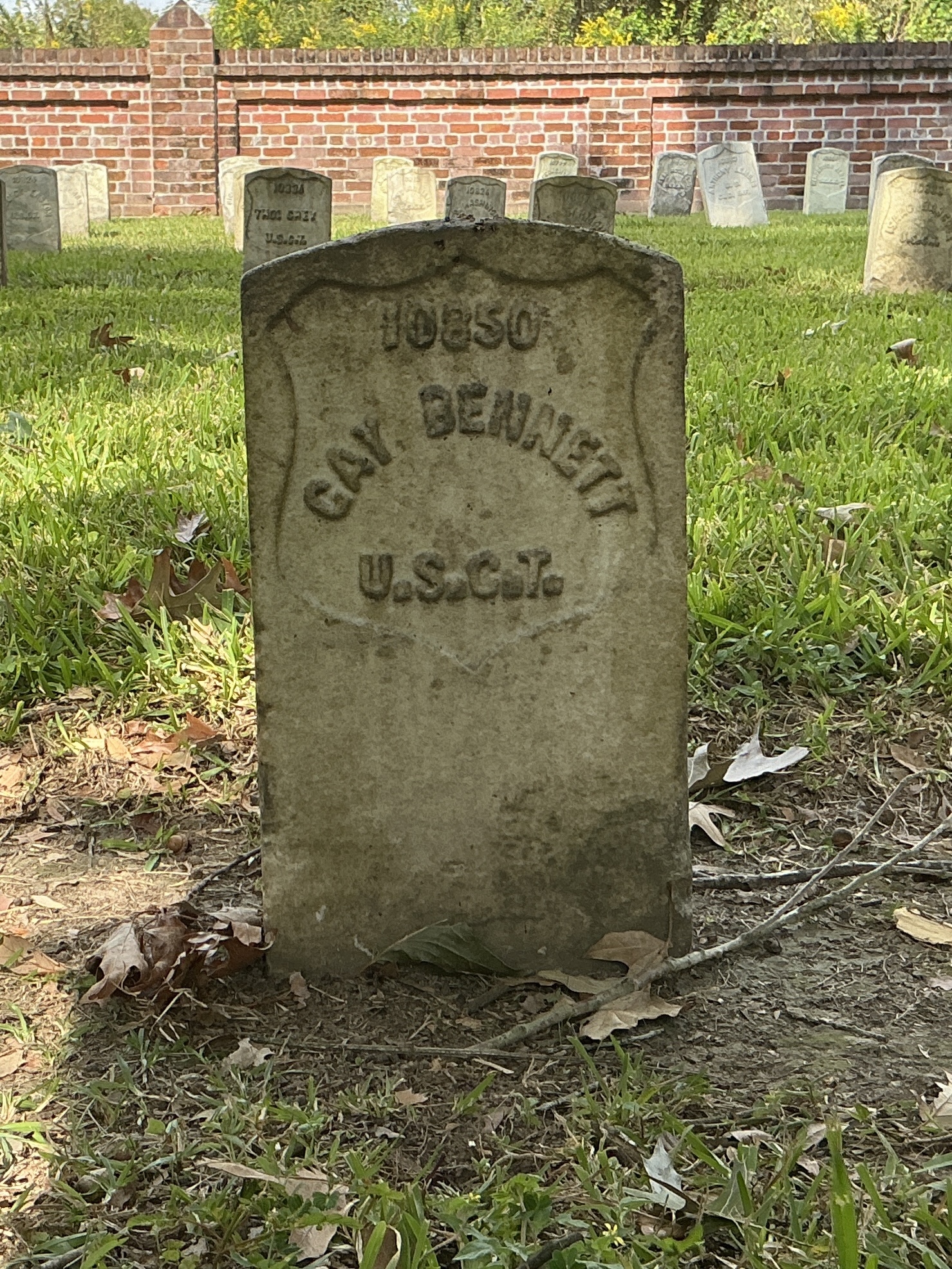 Front of historic upright marble headstone with recessed shield face.