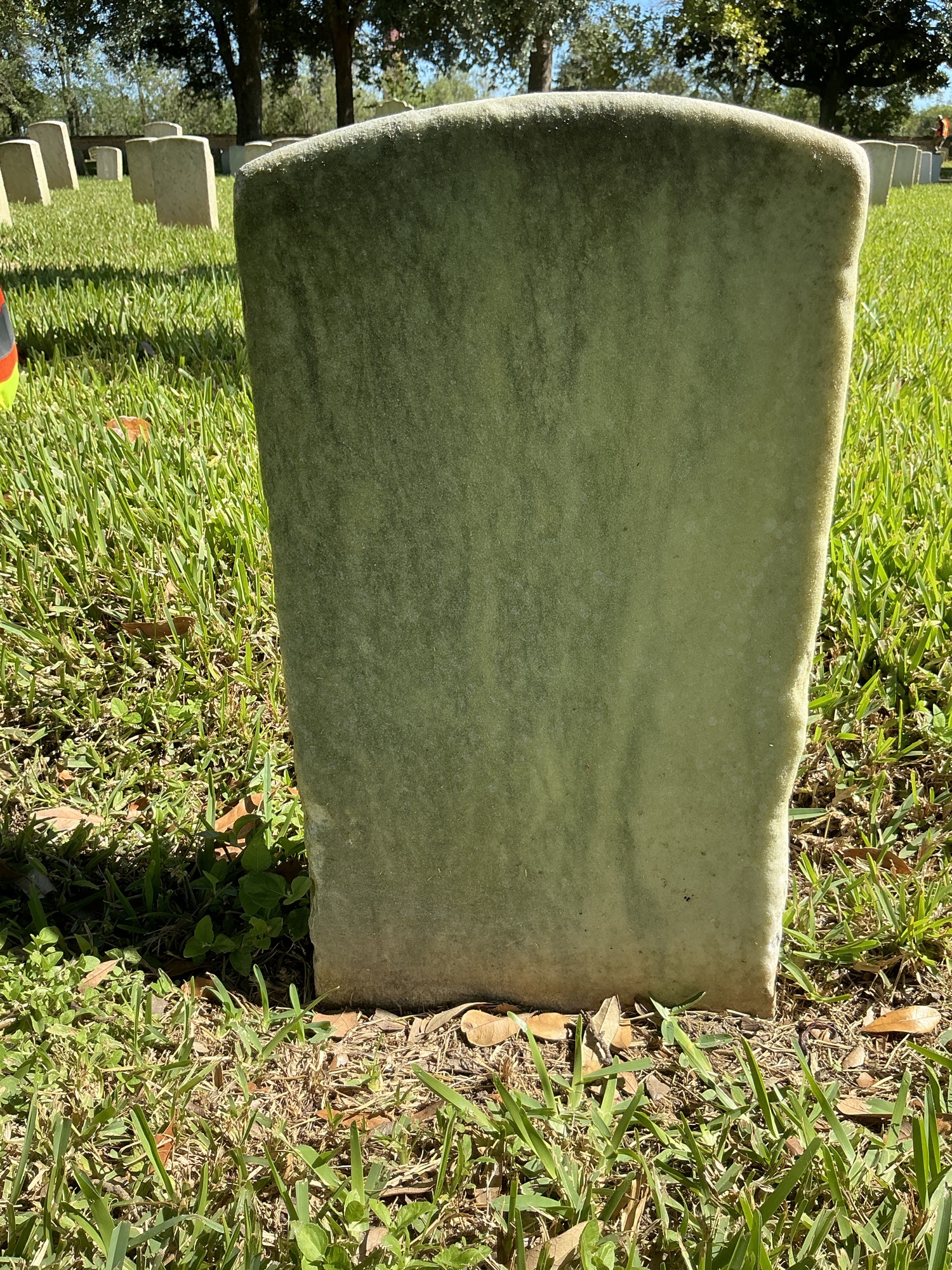 Back of historic upright marble headstone with recessed shield face.