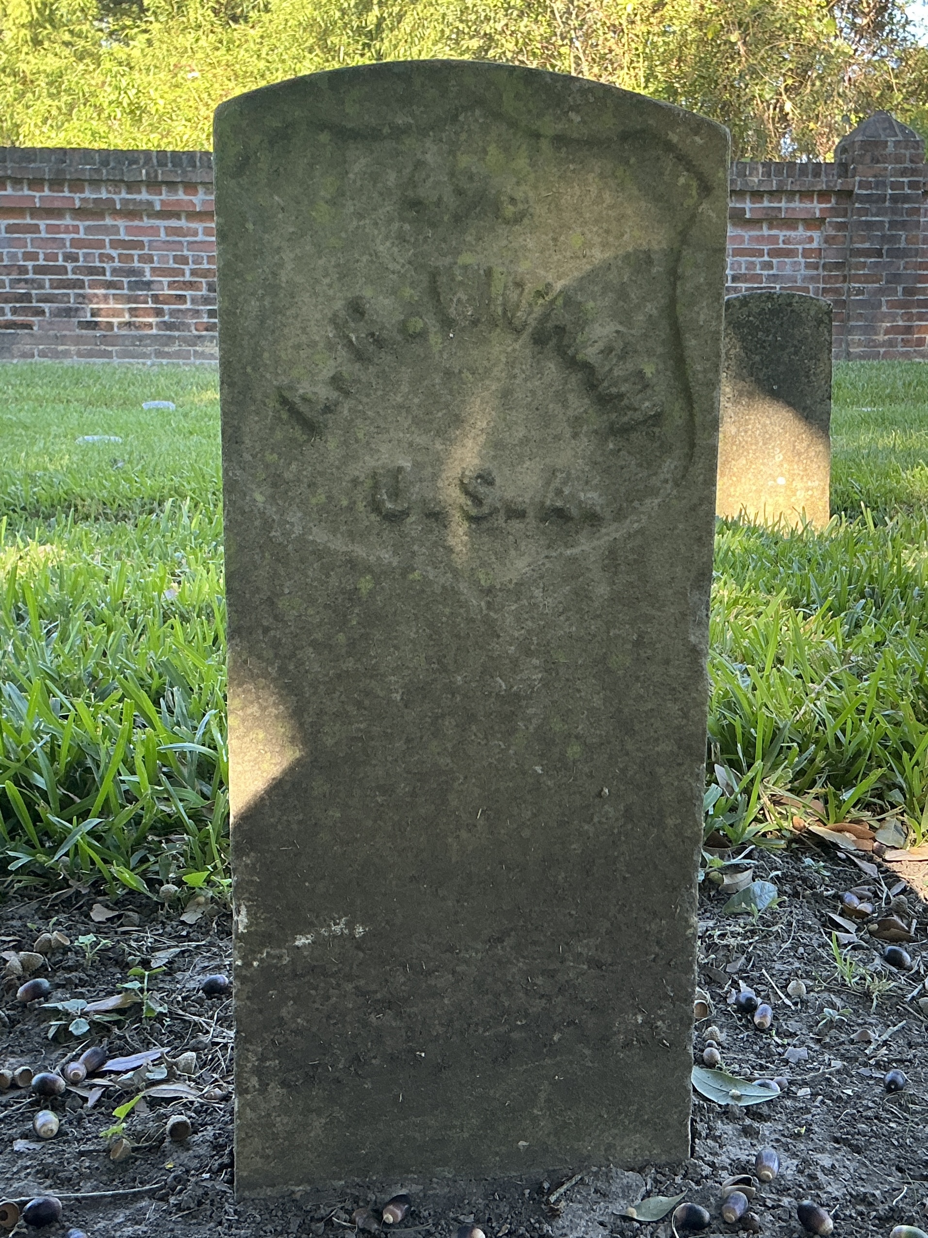 Front of historic upright marble headstone with recessed shield face.