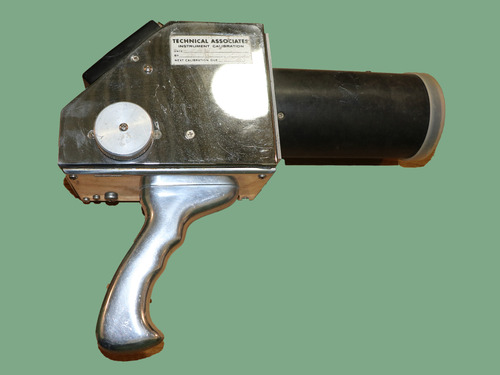 An object that is similar in shape to a hairdryer. There is a label on it that reads "Technical Associates".