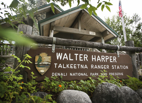 a wooden sign reading walter harper talkeetna ranger station denali national park and preserve, in front of a building