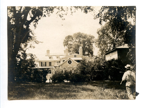 Black and white photograph of man looking at buildings.