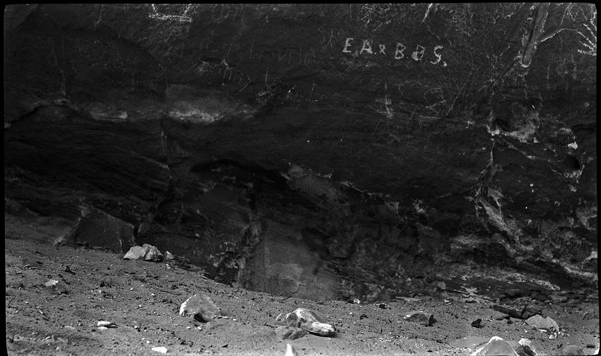 Vandalism - carving of initials and defacing natural rock surface on desert varnish.