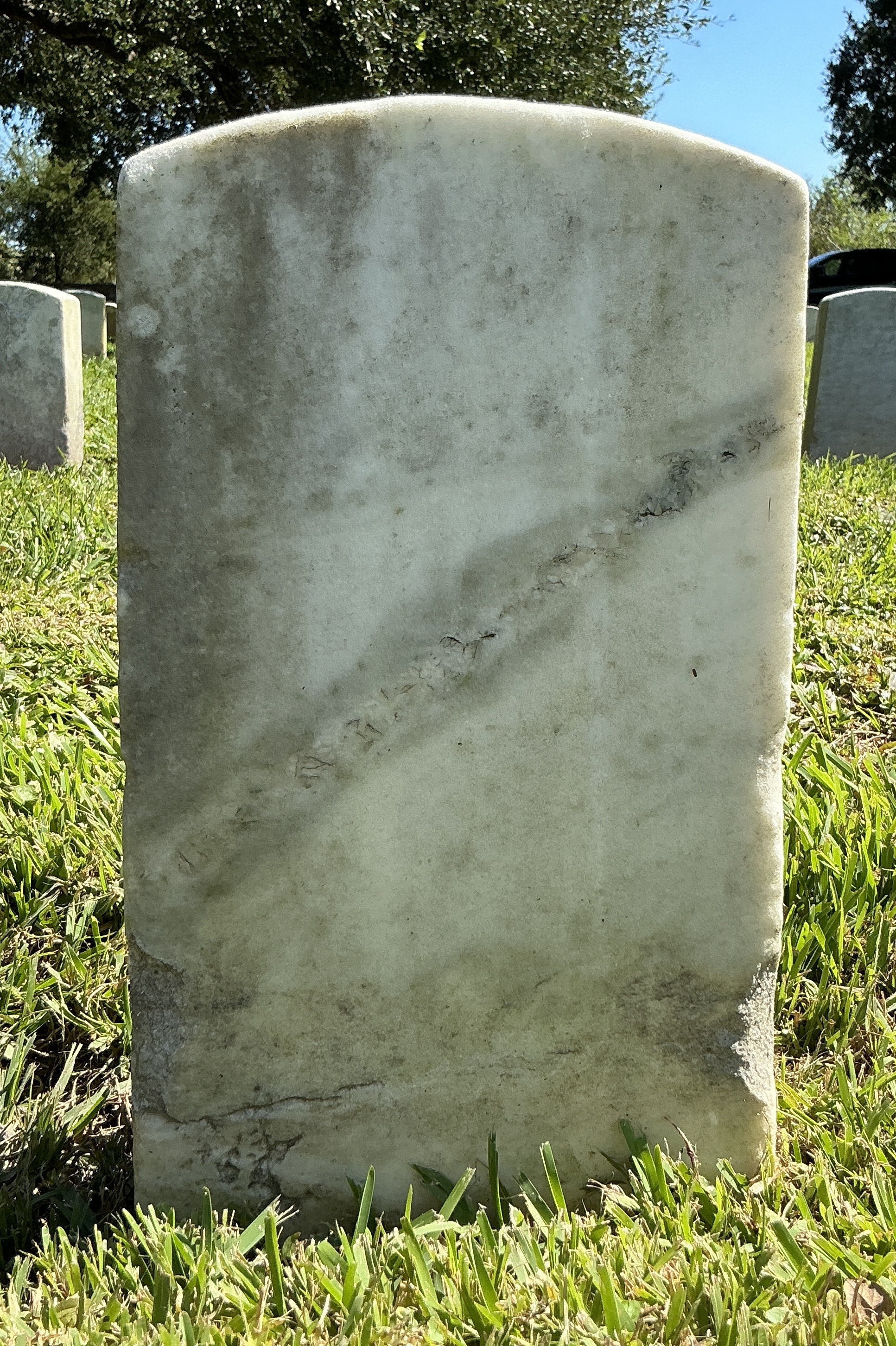 Back of historic upright marble headstone with recessed shield with recessed lettering face.