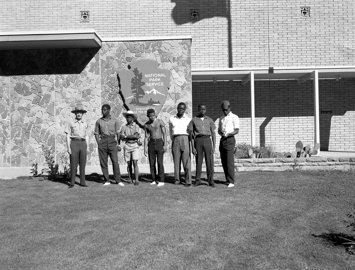 Supervisory Park Ranger Clyde Maxey from Yellowstone National Park and African American students standing in front of Mission 66 Visitor Center and Museum. Group was on tour of Zion National Park.