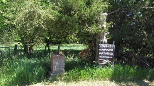 Two signs in the middle of a grassy field.