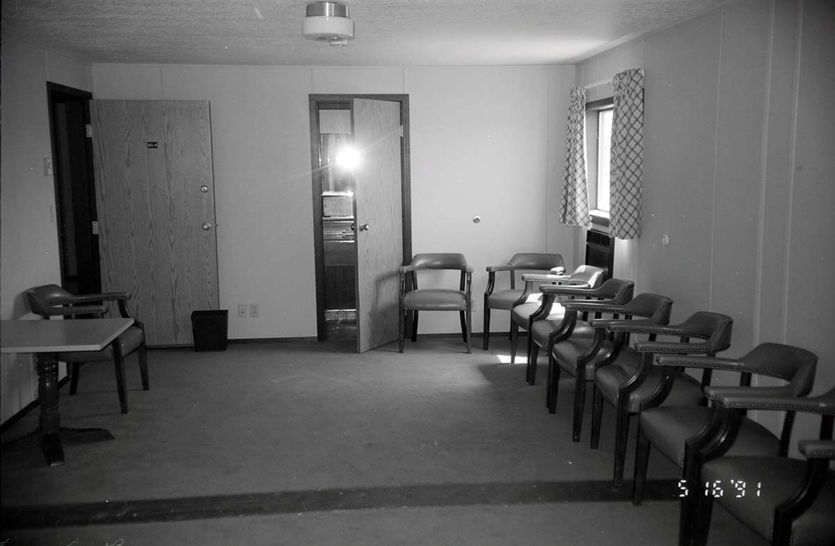 Chairs along wall of living room area in barracks. [Image possibly for comparative housing study]