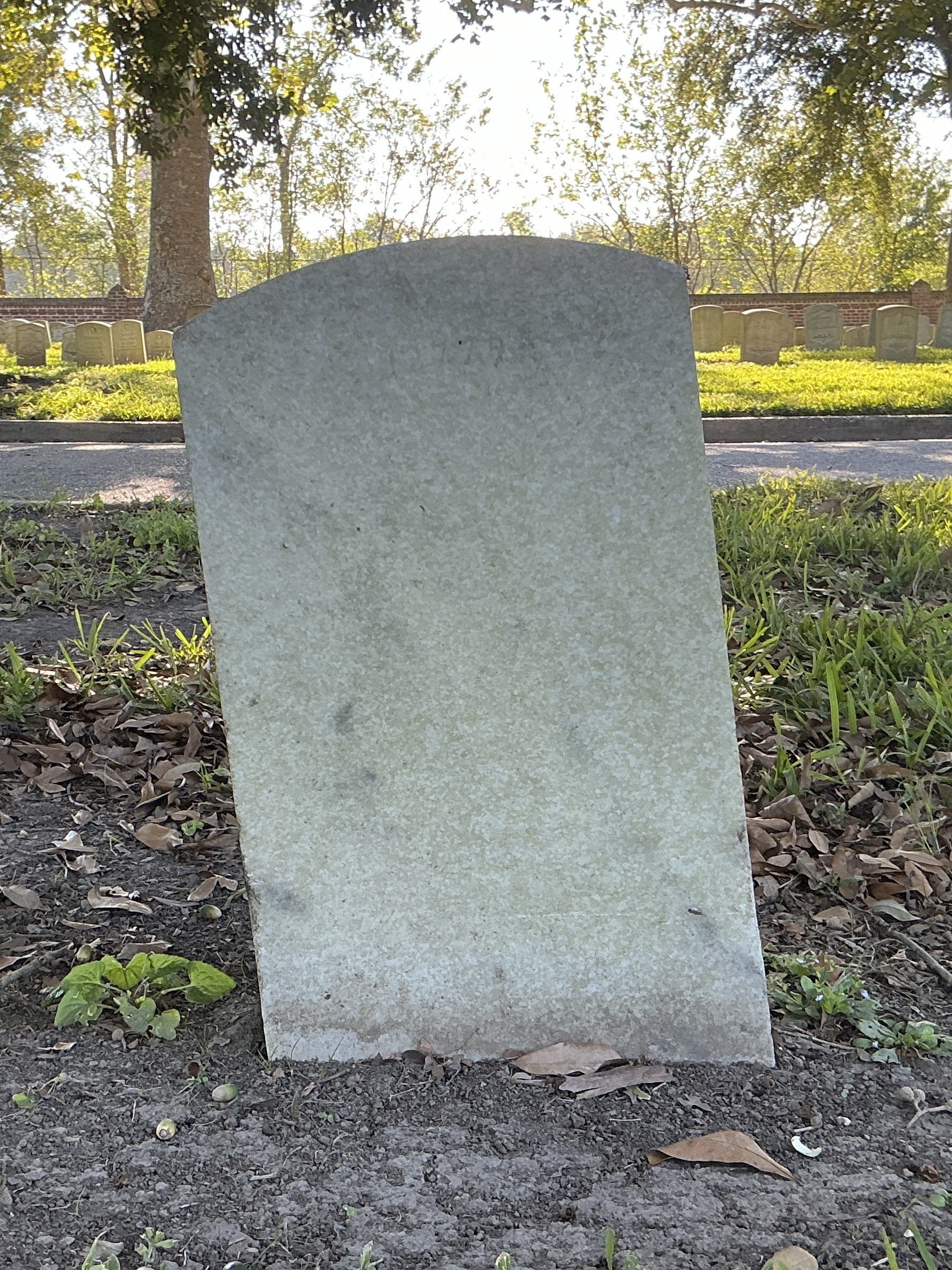 Back of upright marble headstone with flat face.