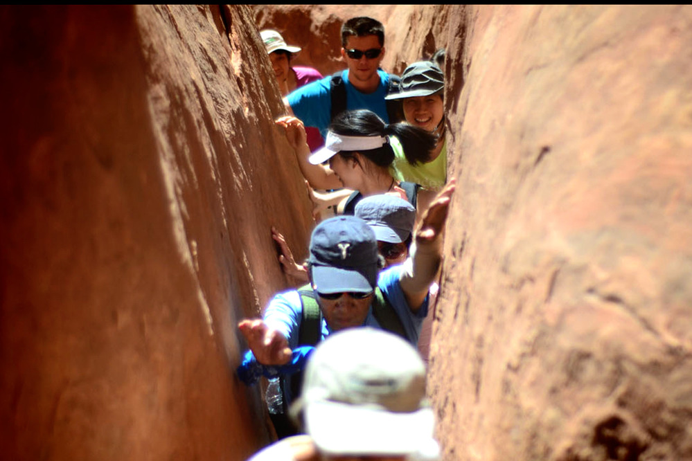 a line of people squeezed between rock walls