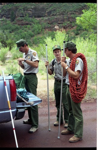 Color photo of SAR team transporting injured man.