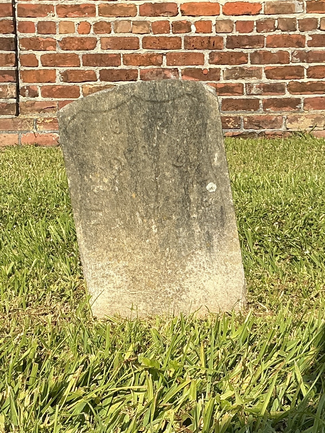Front of historic upright marble headstone with recessed shield face.