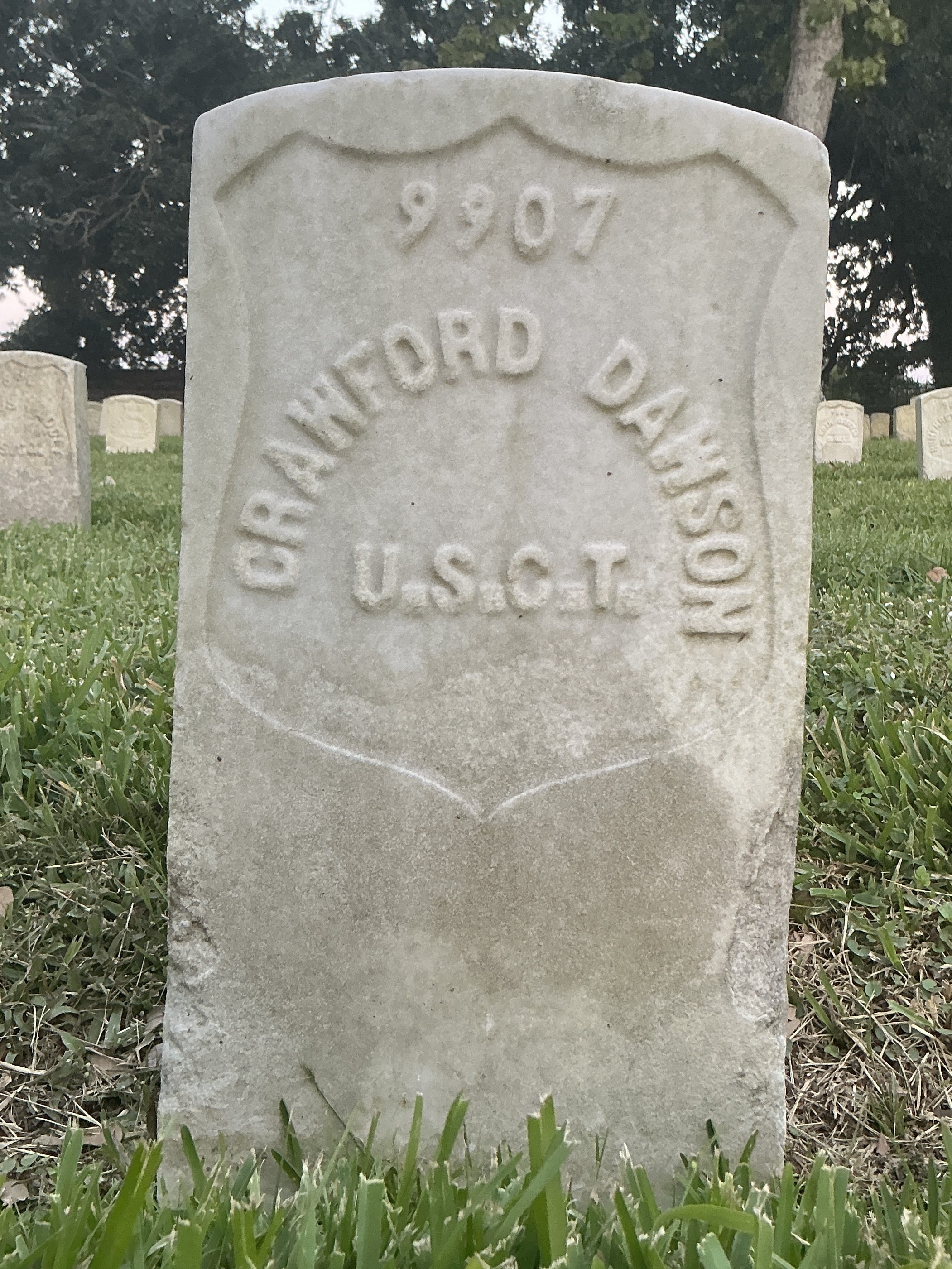 Front of historic upright marble headstone with recessed shield face.