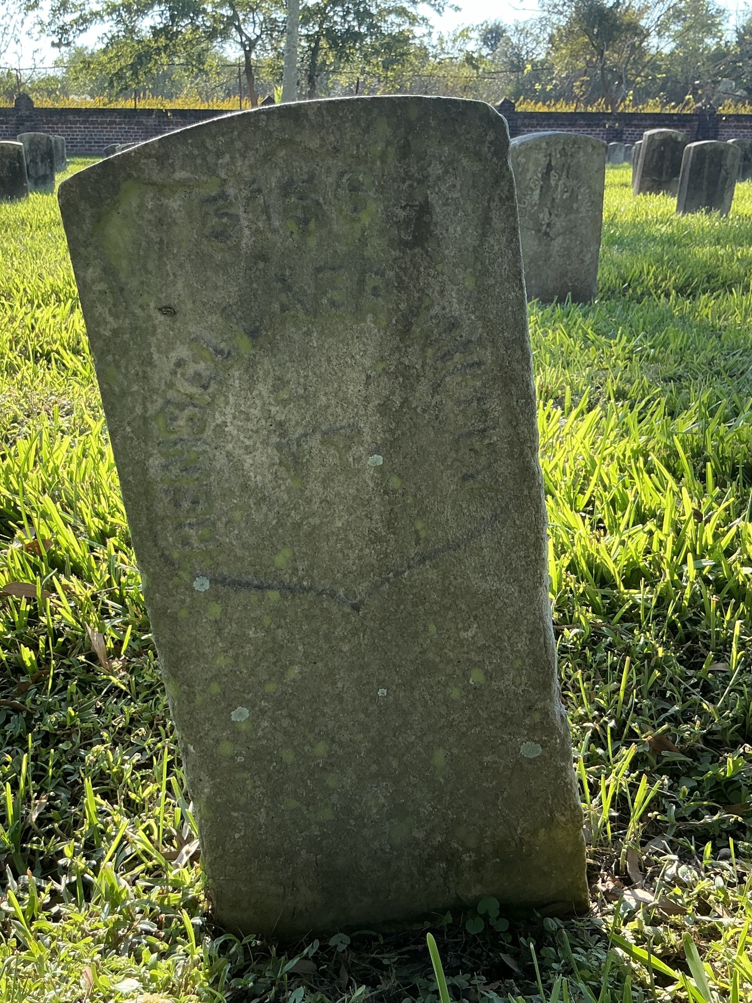 Front of historic upright marble headstone with recessed shield face.