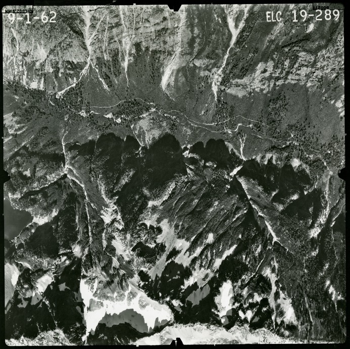 Black and white aerial photograph of glaciated mountain peaks and valleys.
