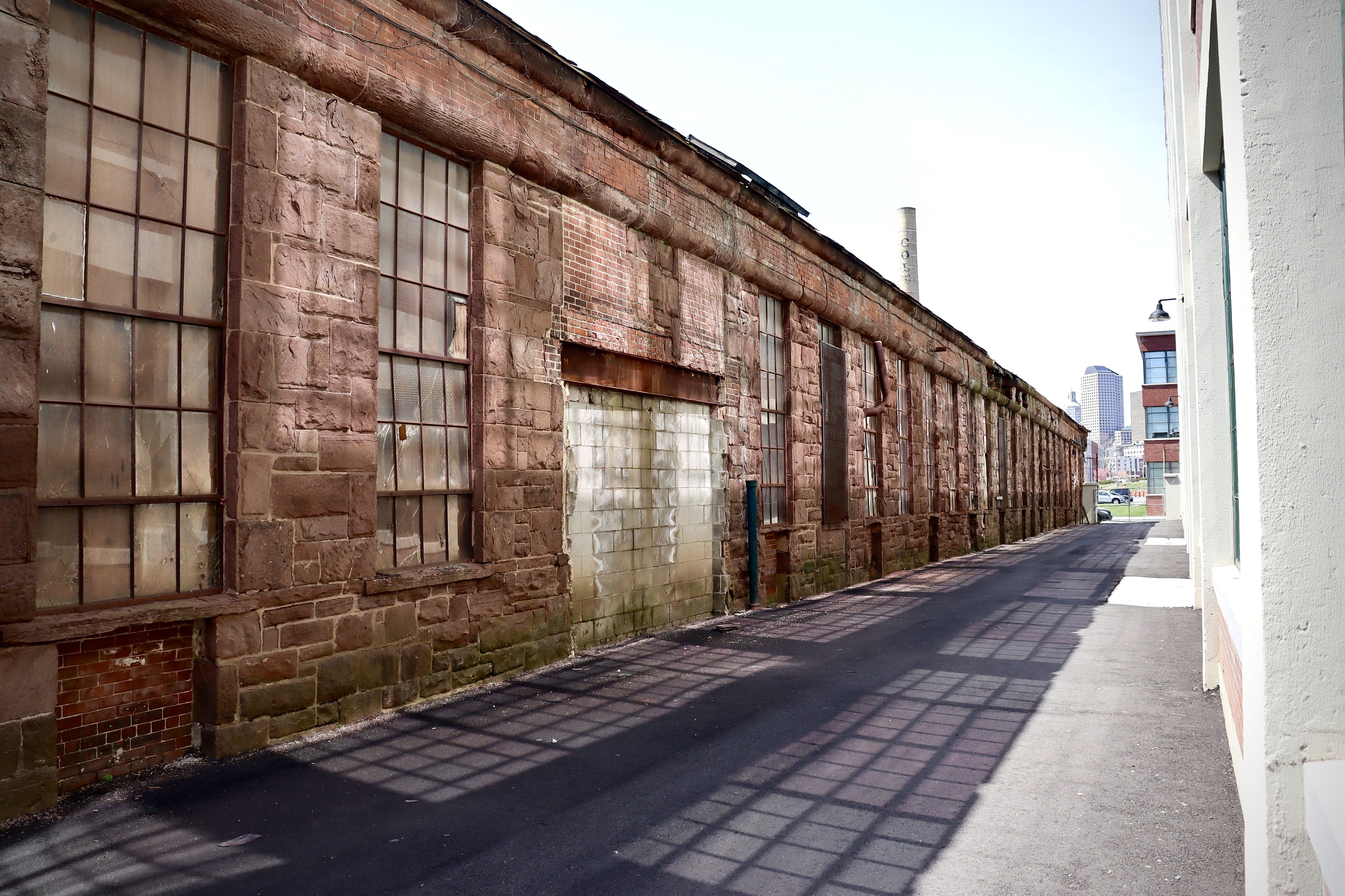 One story brownstone building showing windows that are broken.