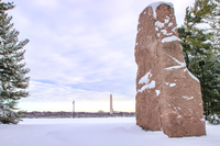 Granite monolith on a plaza after a snowfall with Washington Monument in the distrance