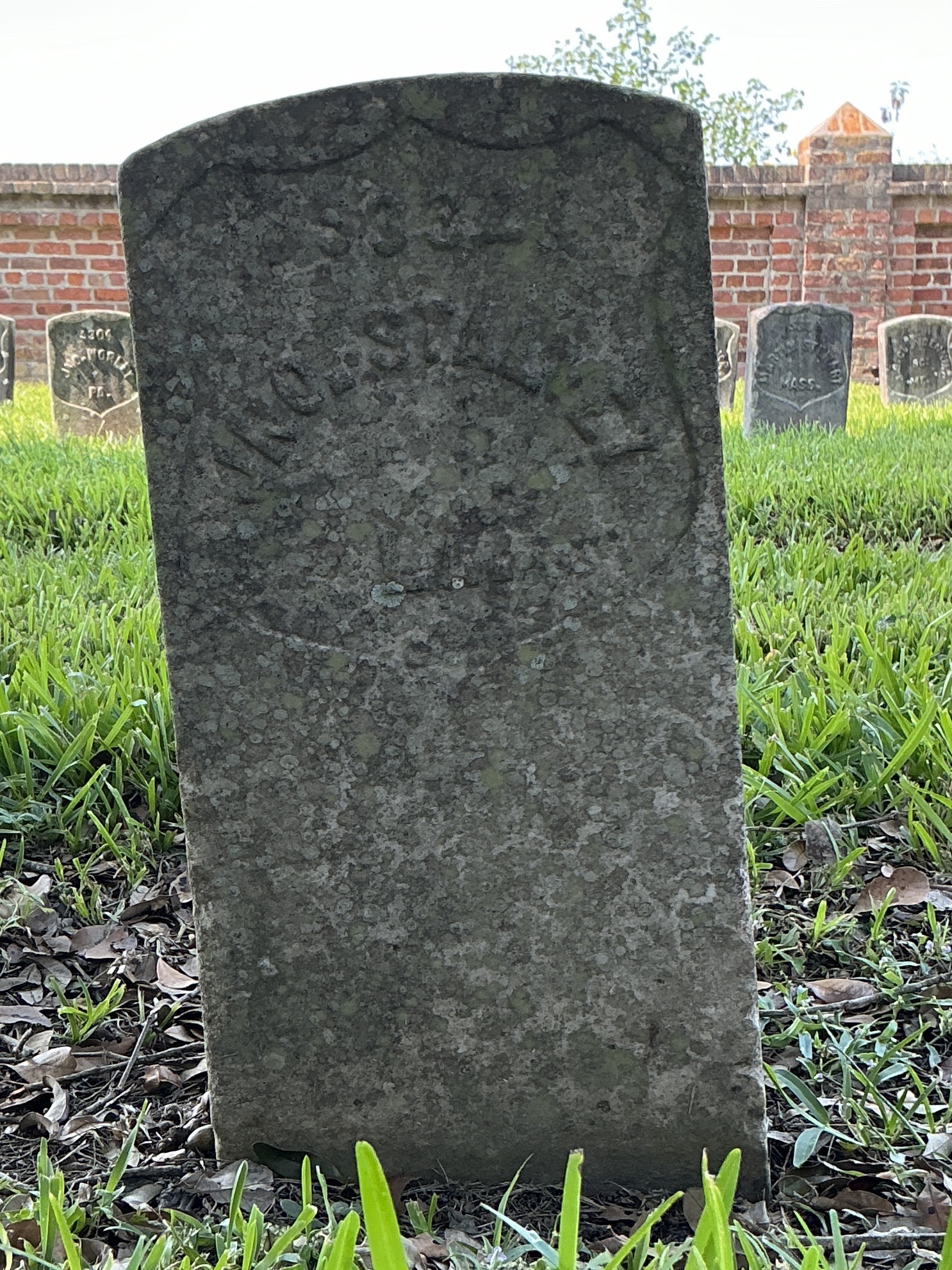 Front of historic upright marble headstone with recessed shield face.