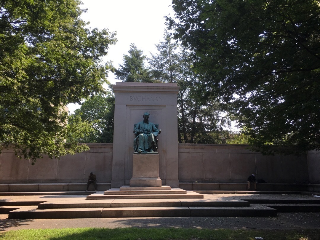 A stone courtyard with a statue of James Buchanan on a pedestal