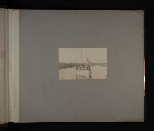 Photograph of a sailboat in a body of water with a group of people aboard