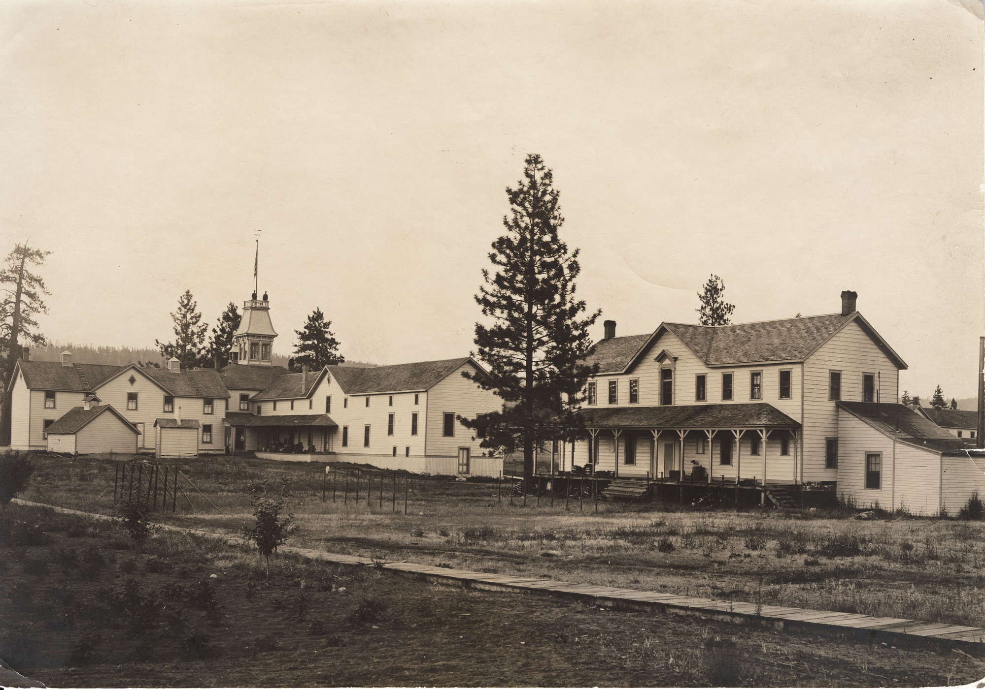 Black and white photograph of several multi-story wooden buildings