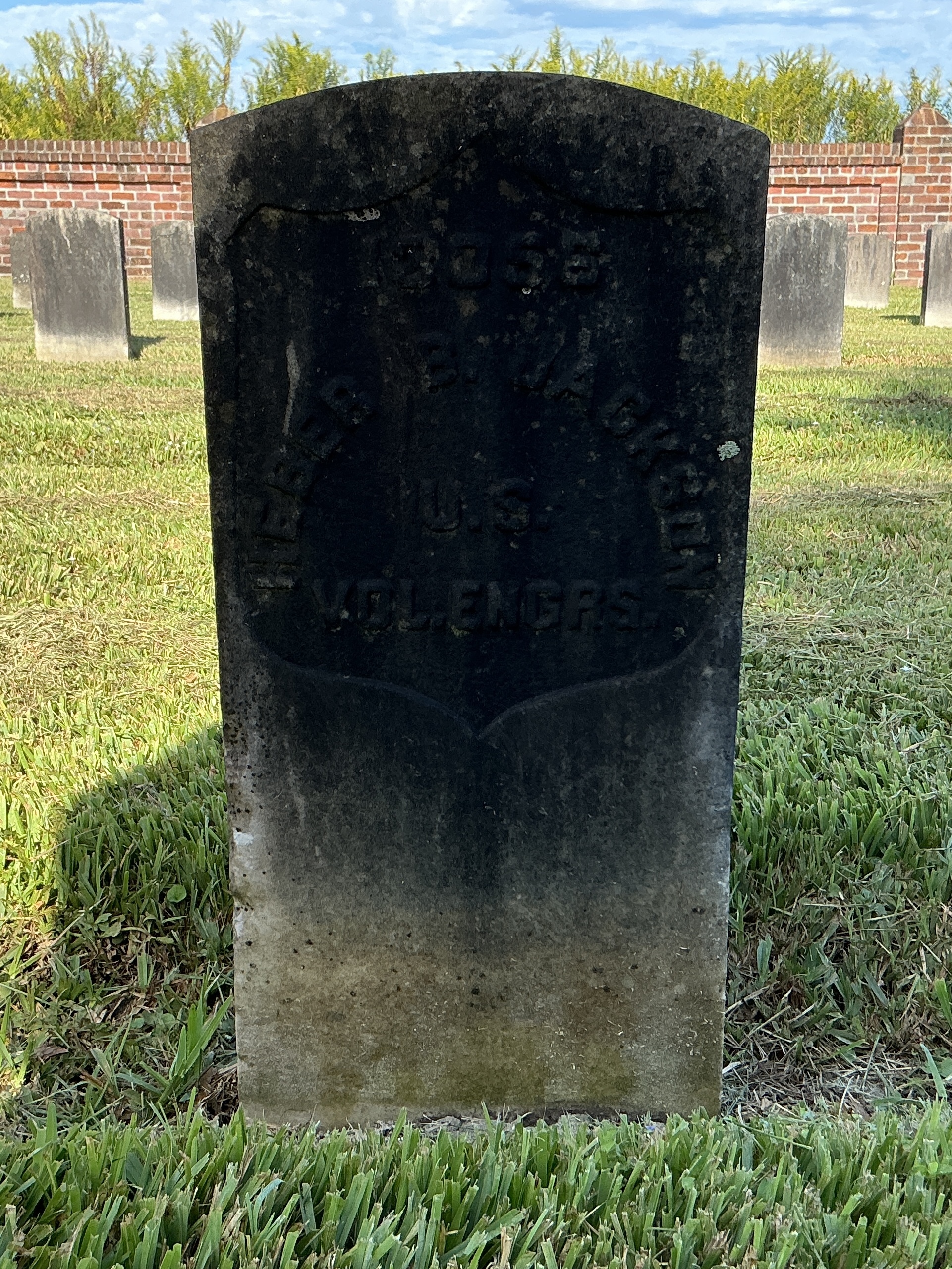 Front of historic upright marble headstone with recessed shield face.
