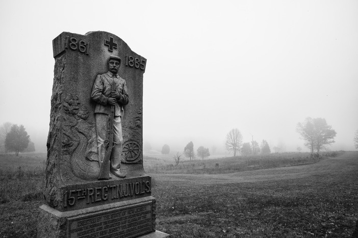 Black and white photograph of a stone monument with relief of Civil War soldier that says, 15th REG NJ VOL's, and the years 1861 to 1865.