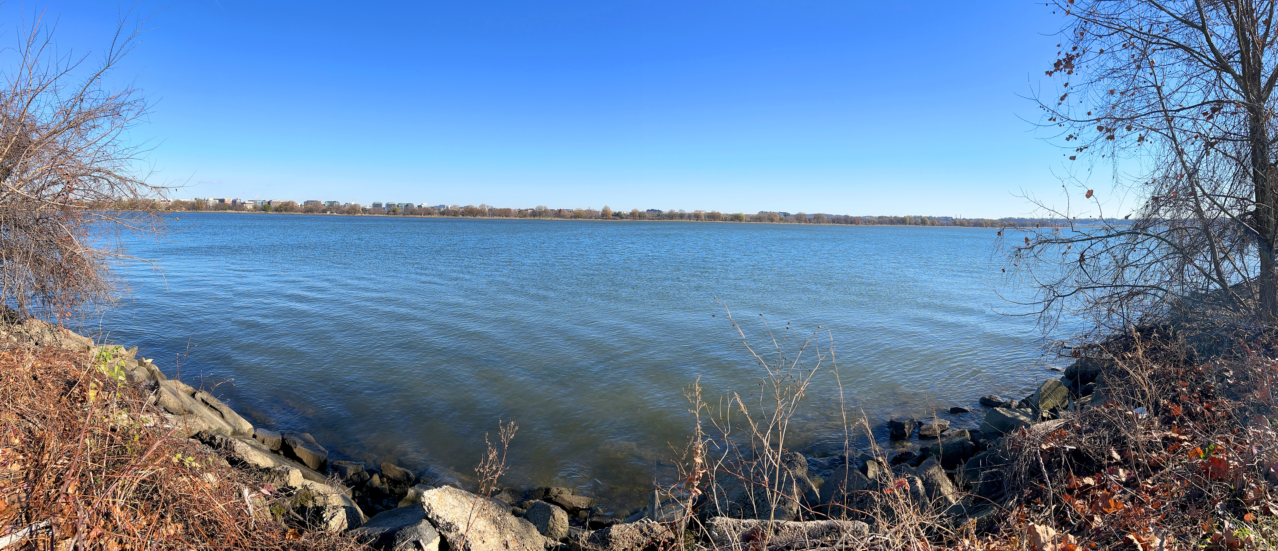 rocky shoreline looking out onto calm, wide river