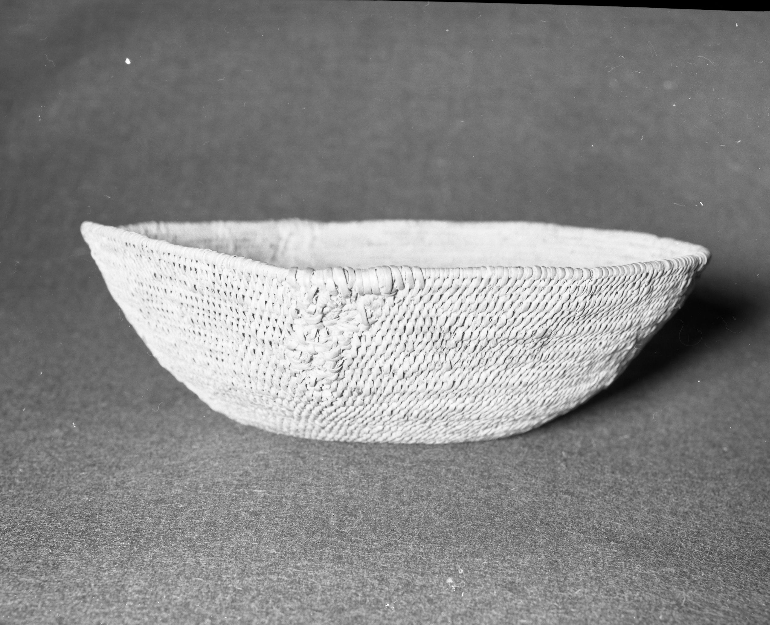 Mrs. Geraldine McConnel Collection. Object: Miwok basket. Dimensions: 9 1/2" x 3". Materials: Scrapped shoots, split bull pine branchlets. Technology: Single rod: interlocking stitch, clockspring start. Heavy repair on each side in the same material. Collection History: From a member of Mrs. McConnell's family that lived in Sonora. Thought to have been acquired from a Miwok woman in Sonora probably c. 1900. Photographed by Michael Dixon in January 1983. Catalogued by Craig Bates and Barbara Beroza. Yosemite Collections, National Park Service.