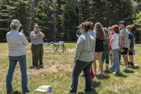 Group of students and teachers gathered outdoors, listening to an Park Ranger at Carroll Homestead.