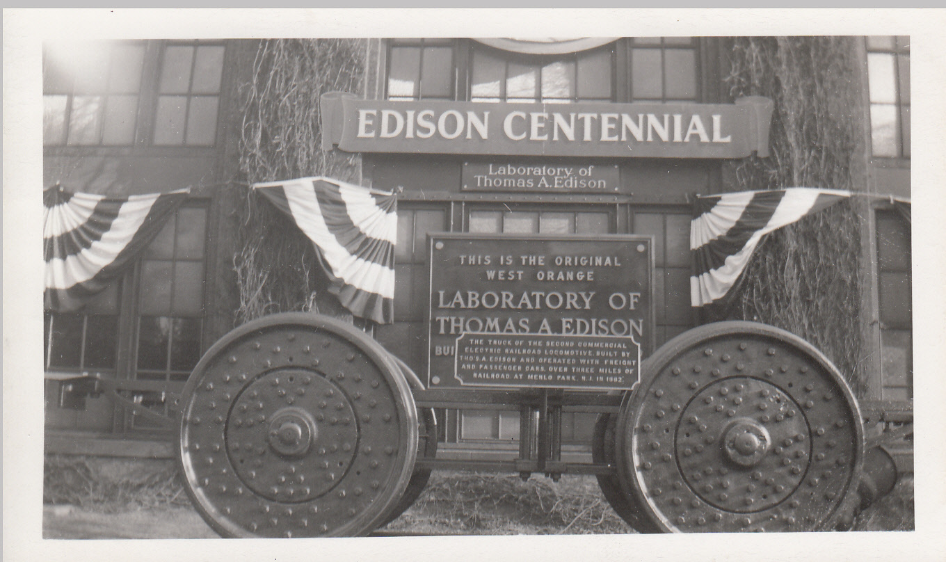 Wheels used under first electric locomotive, in front of Building 5, which is decorated for the Centennial of Edison's birth.