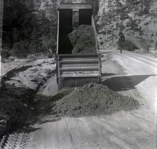 Dump truck dumping dirt during east side road repair and turn out construction.