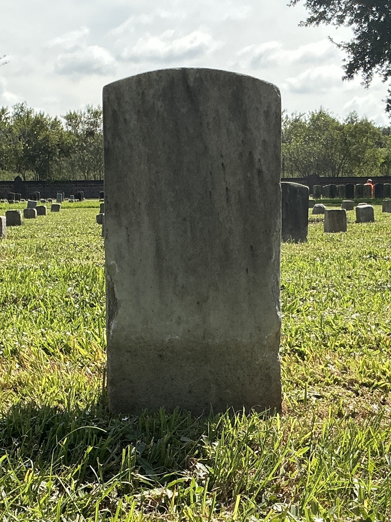 Back of historic upright marble headstone with recessed shield face.