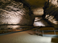 A large cave passage with a paved trail.