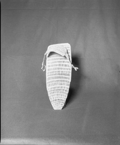 Mrs. Donald Segerstrom Collection. Object: Paiute model cradle board. Dimensions: 16 1/2" height. Materials: Willow, blue calico. Technology: Backboard plain twined, start cut and bent upward, hood diagonally twined, up to right slant of turns. Photographed by Michael Dixon. Catalogued by Craig Bates and Barbara Beroza. Yosemite Collections, National Park Service. 1/83.