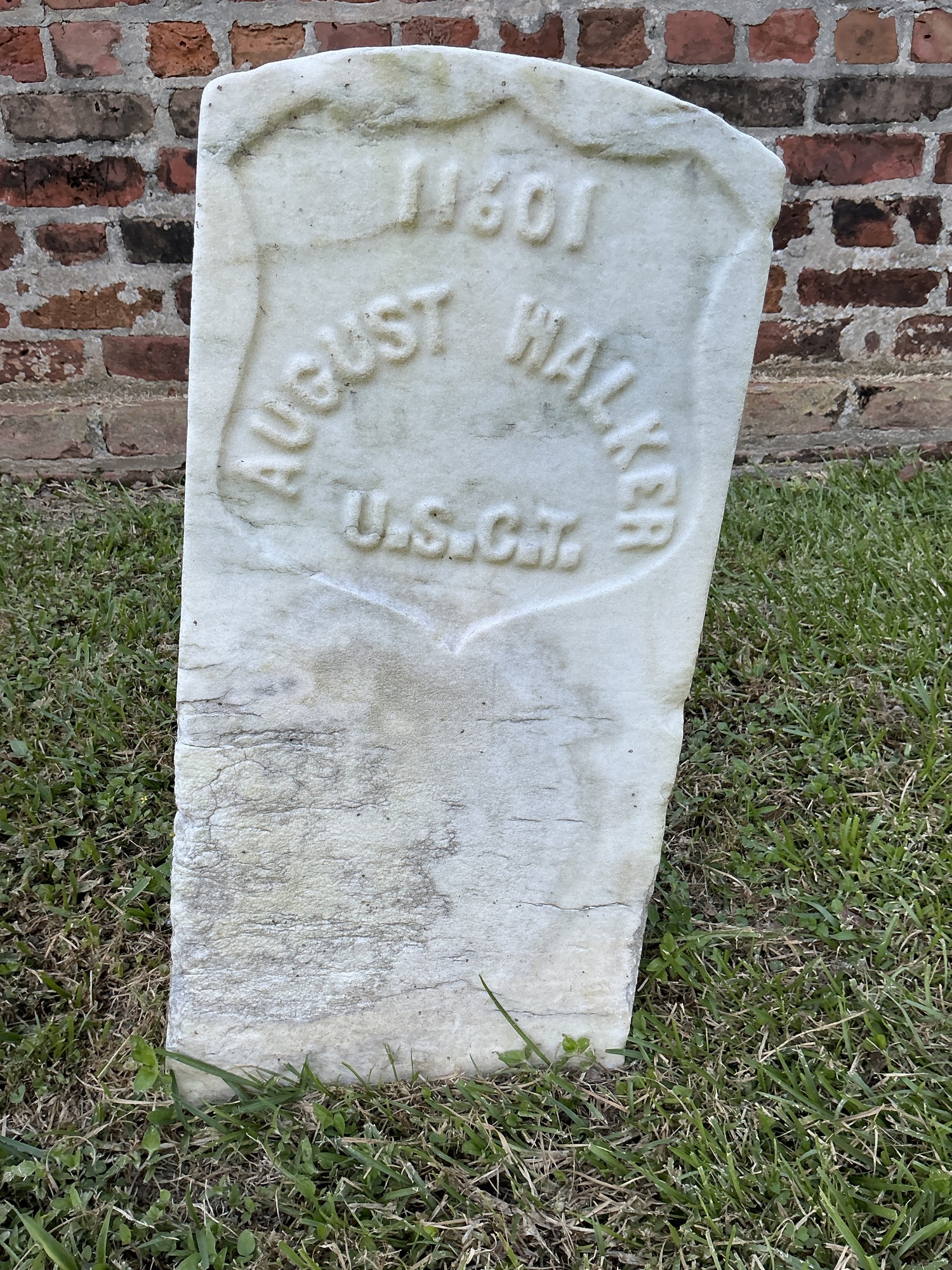 Front of historic upright marble headstone with recessed shield face.