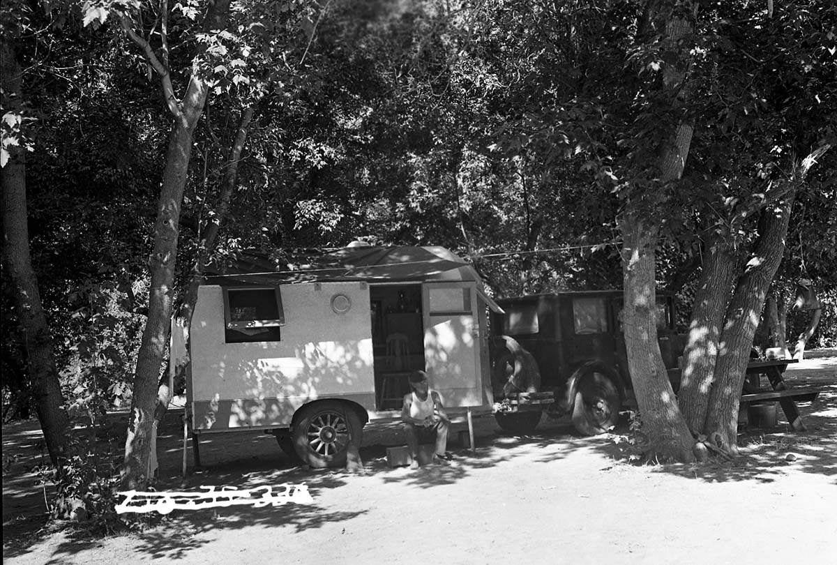 An older gentleman (skipper?) Seated on the step of his camping trailer in the Grotto Campground.