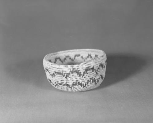 Private Collection. Object: Miwok basket. Dimensions: 4 3/4 x 2 1/2". Materials: Split redbud in the spring, bracken fern root. Technology: Clockspring start. Single rod, interlocking stitch, fag ends trimmed on work face, a few tucked behind preceding stitch moving ends trimmed on interior, rim finish plain. Collection History: Calaveras County, Calif. Possibly from Arollas family, Angels Camp Area. Photographed by Michael Dixon. Catalogued by Craig Bates and Barbara Beroza. Yosemite Collections, National Park Service.
