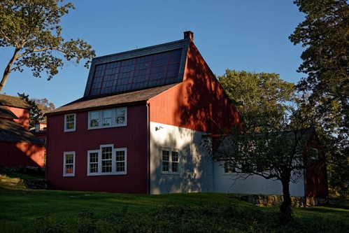 A red building with a white addition, white trim, and several windows.