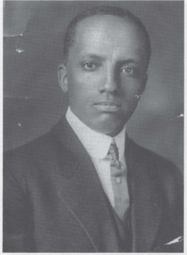 A portrait of a young African American man in a suit and tie. He looks directly at the camera with a serious expression.
