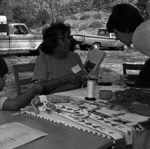 Yetta Jake, Paiute, demonstrates beading and leather work to a visitor at third Folklife Festival at Zion National Park Nature Center, September 1979.