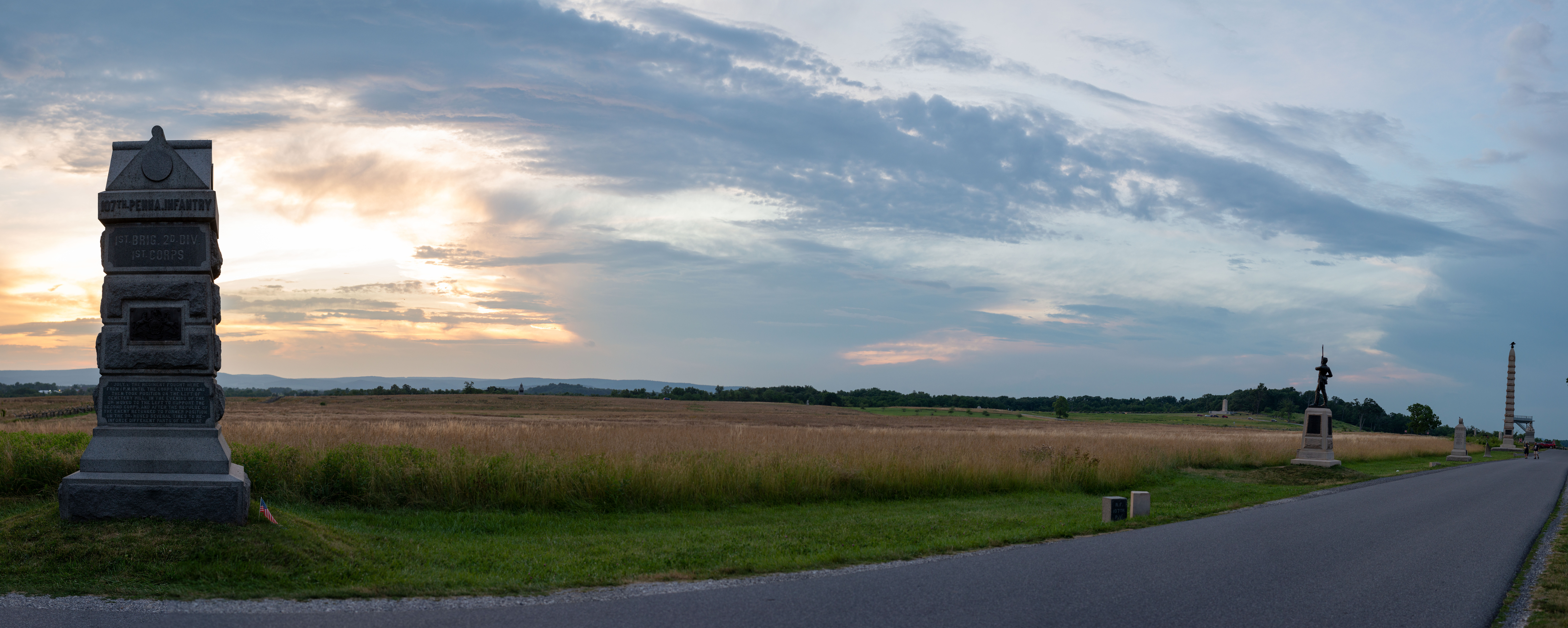 A wide image showing a street lined with various stone Civil War monuments.