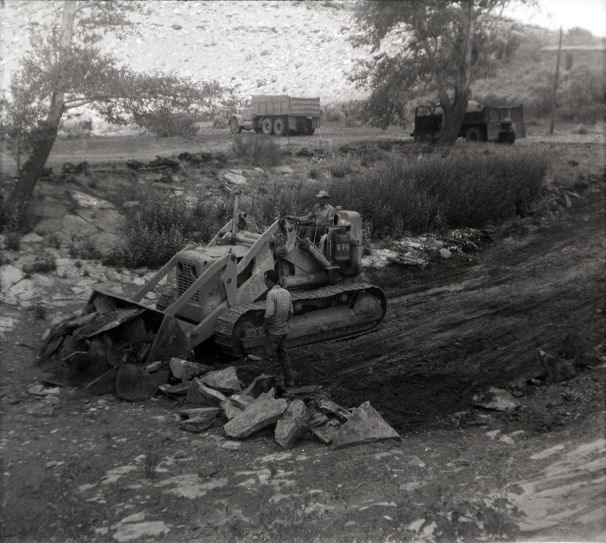 Men using tractor to clear rocks out of the road along the scenic canyon drive near the Grotto.