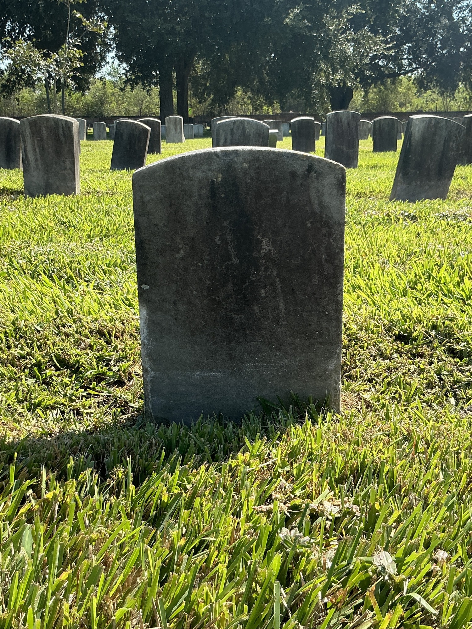 Back of historic upright marble headstone with recessed shield face.