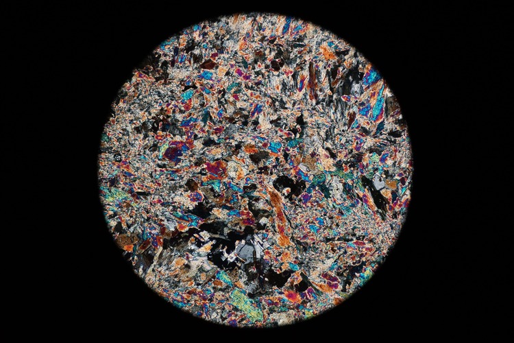Circular microscopic image of rock structure.