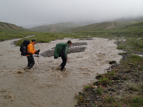 two people walking through knee-deep water